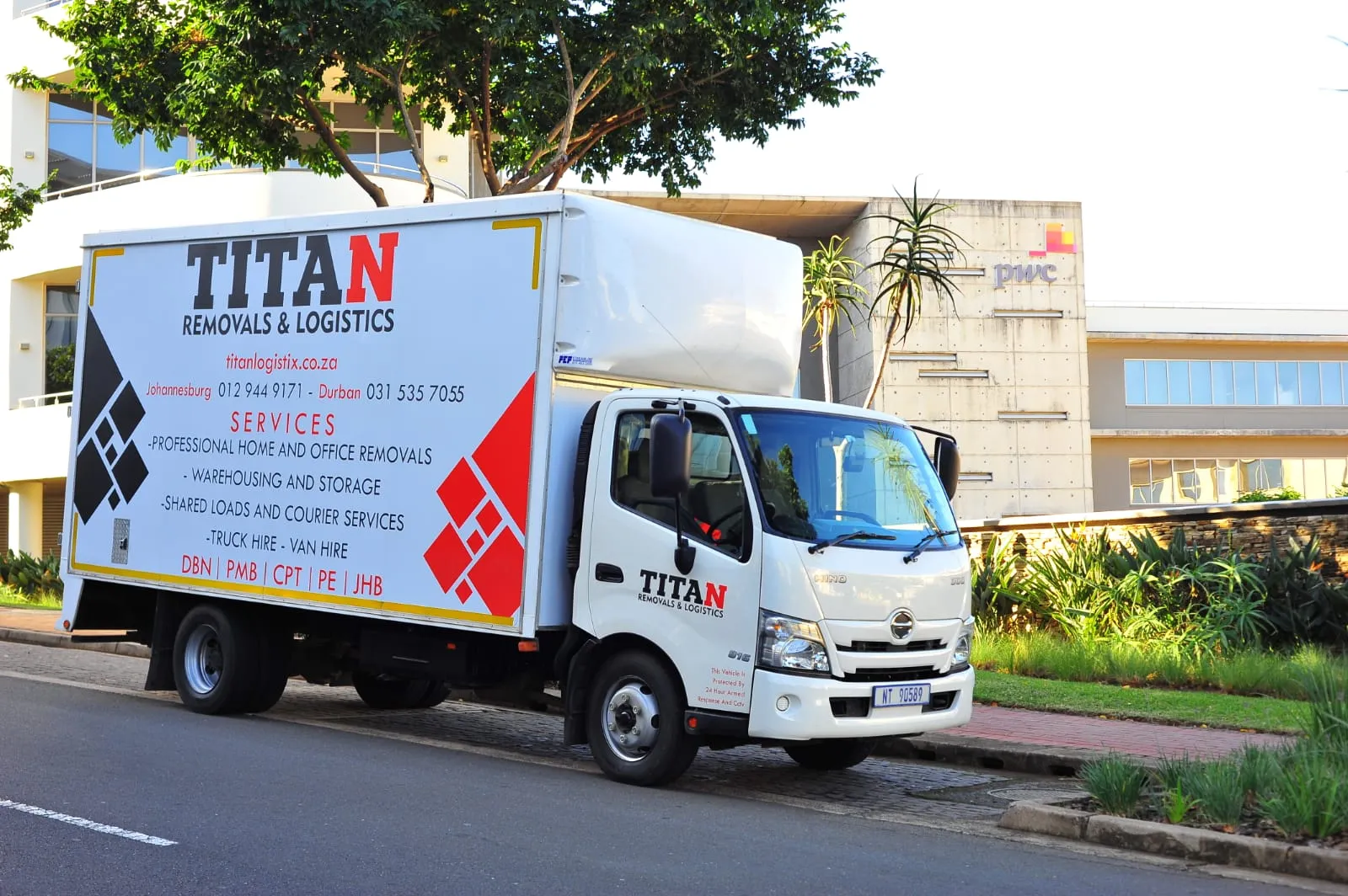 Titan Logistix branded truck parked outside commercial offices